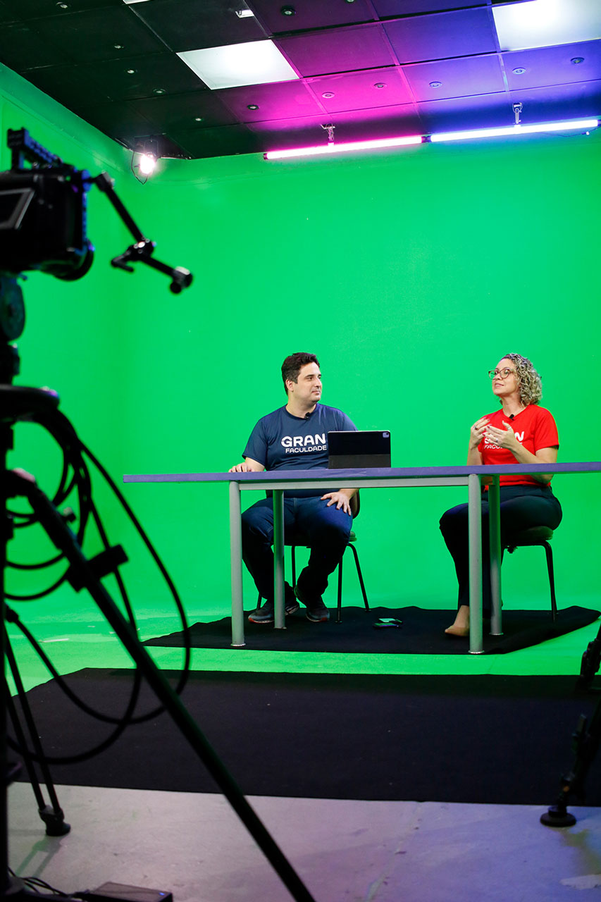 Gravação de vídeo aula com bancada e cenário virtual.